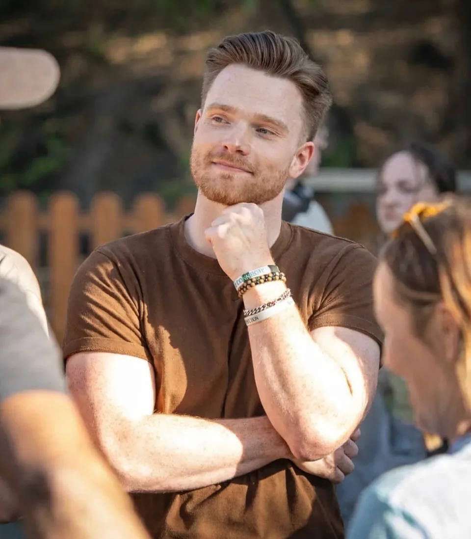Eric, founder of Maya Studios, outdoors with his hand resting under his chin